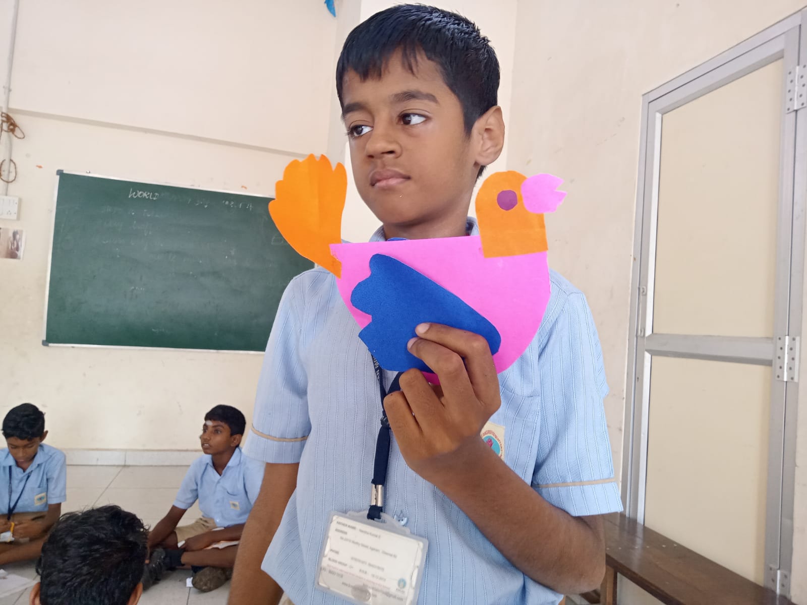 KRM Special School student showing a colourful paper bird craft