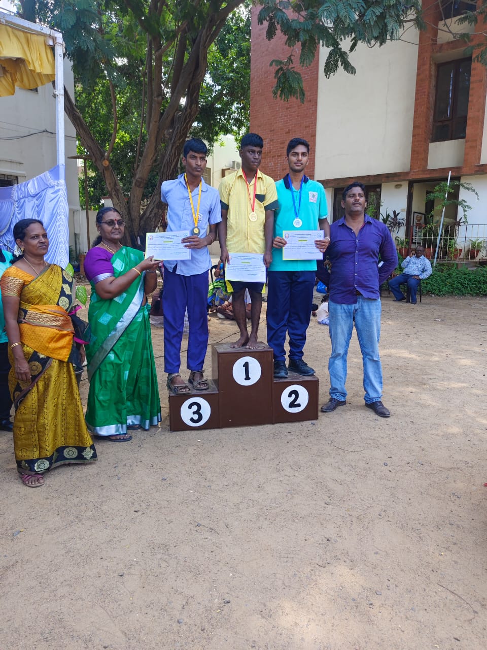 KRM Special School students receiving certificates on the athletics winners' podium
