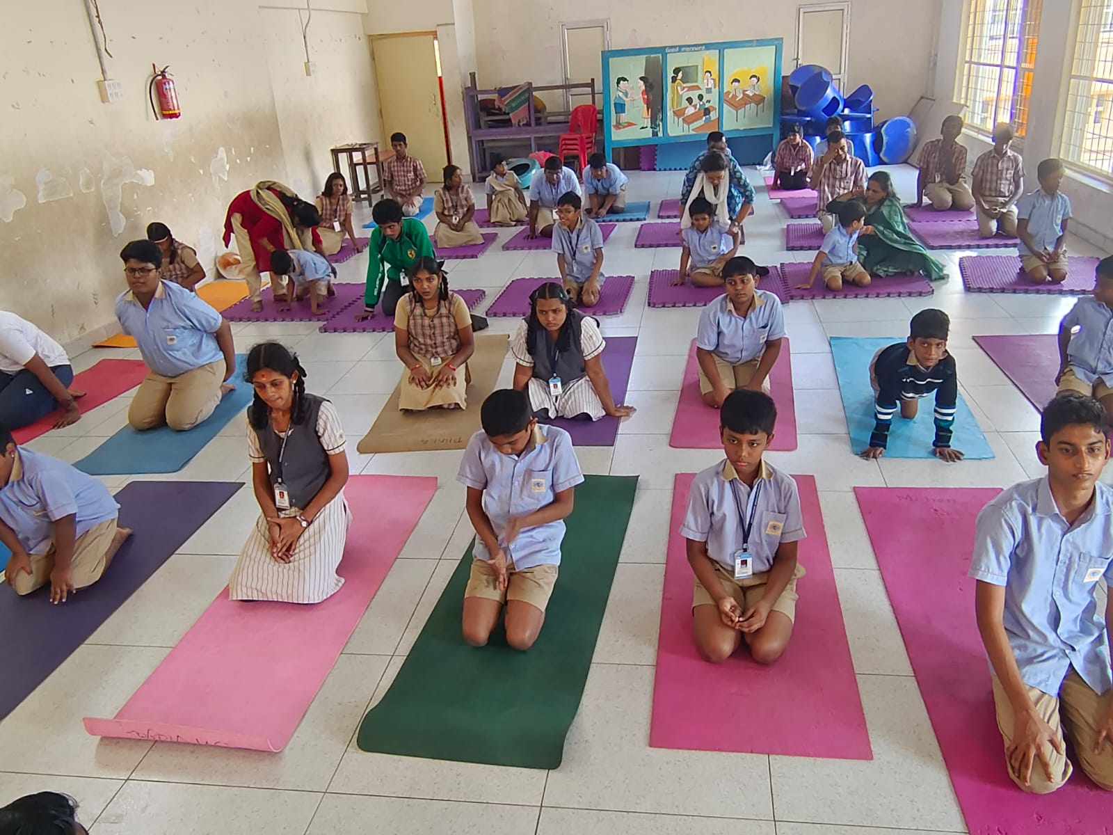 KRM Special School students kneeling on yoga mats in the school hall